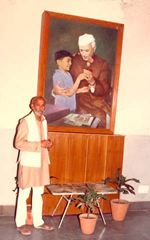 Photo of Vishnu Chinchalkar standing in front of a painting of  Jawaharlal Nehru